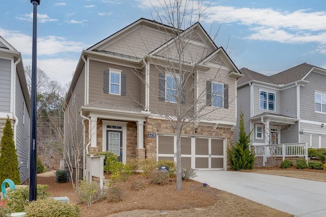 craftsman-style house featuring a garage, stone siding, and concrete driveway