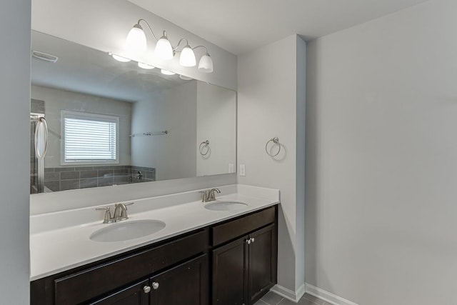 bathroom featuring double vanity, baseboards, and a sink