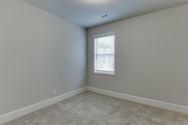 unfurnished room with light carpet, baseboards, and visible vents