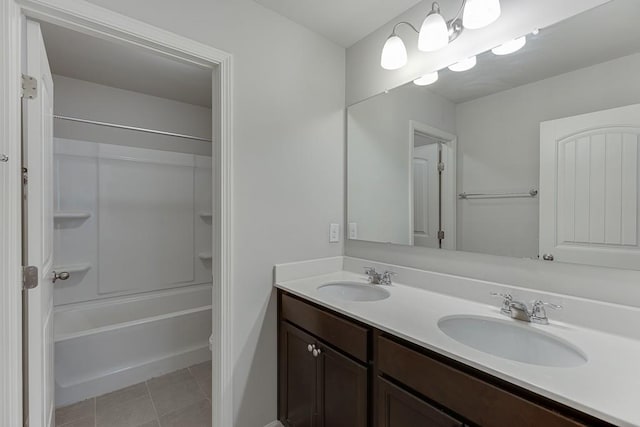 full bath featuring double vanity, bathtub / shower combination, tile patterned flooring, and a sink