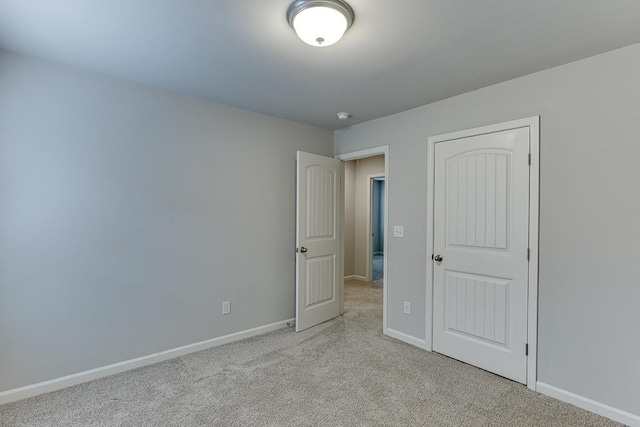 unfurnished bedroom featuring baseboards and light colored carpet