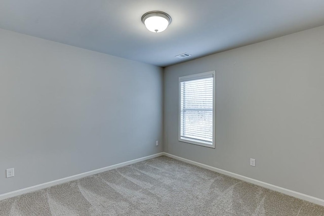 empty room featuring baseboards, visible vents, and carpet flooring