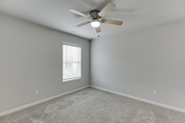 carpeted empty room with visible vents, ceiling fan, and baseboards