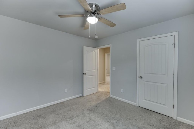 unfurnished bedroom with carpet floors, a ceiling fan, and baseboards