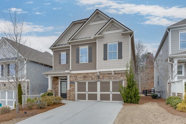 craftsman inspired home with stone siding, driveway, and an attached garage