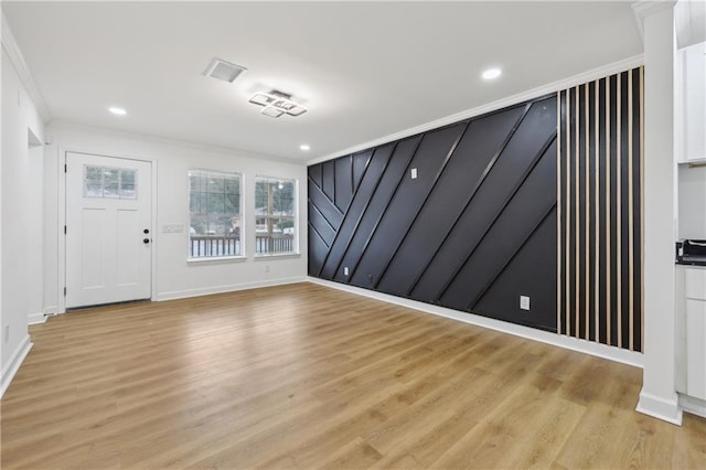 unfurnished room featuring crown molding and light wood-type flooring