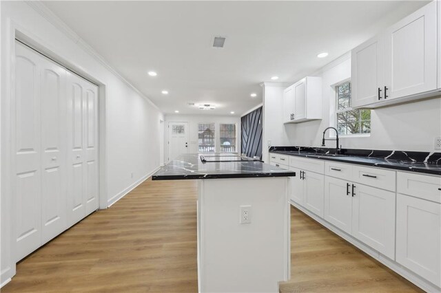 kitchen featuring dark stone countertops, sink, range with electric stovetop, and a center island