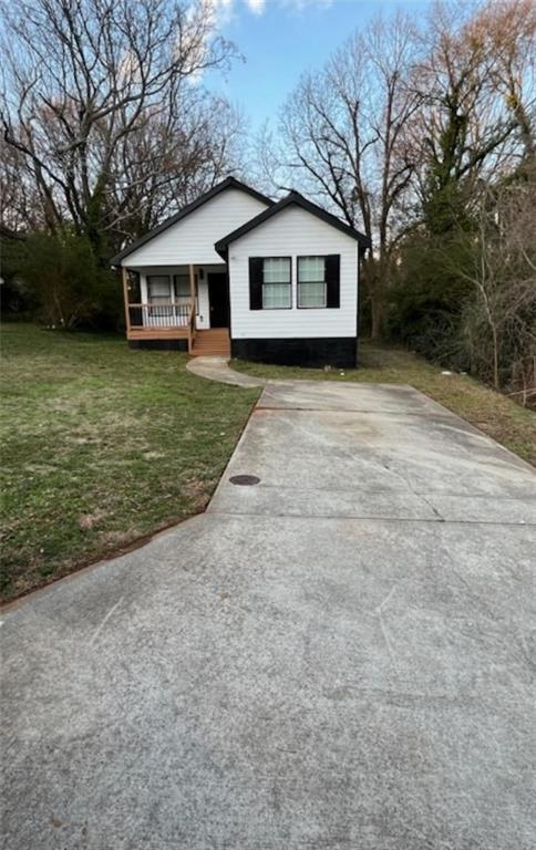 view of front of property with a porch and a front lawn