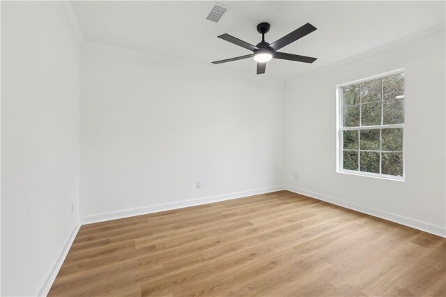 empty room with crown molding, a wealth of natural light, ceiling fan, and light hardwood / wood-style flooring