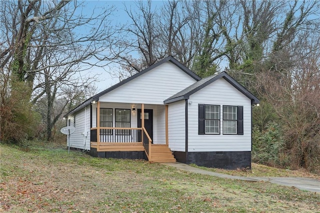 bungalow-style house featuring covered porch and a front lawn