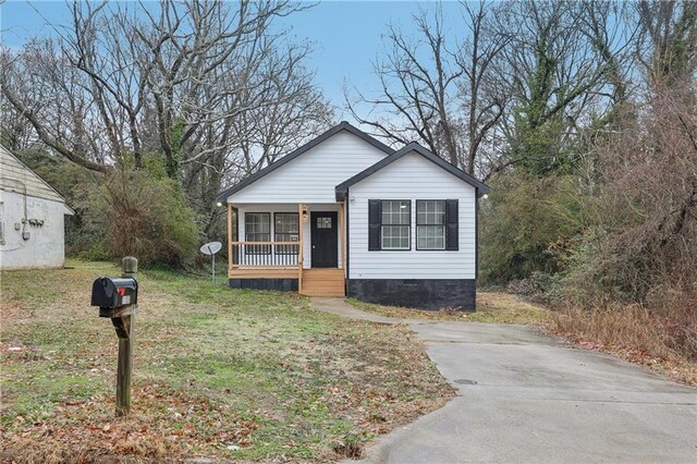 view of front of house with a front yard and covered porch