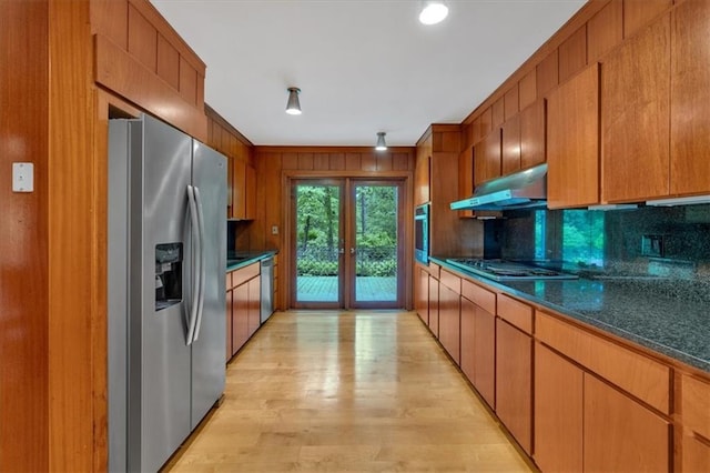 kitchen with stainless steel appliances, under cabinet range hood, decorative backsplash, french doors, and light wood finished floors