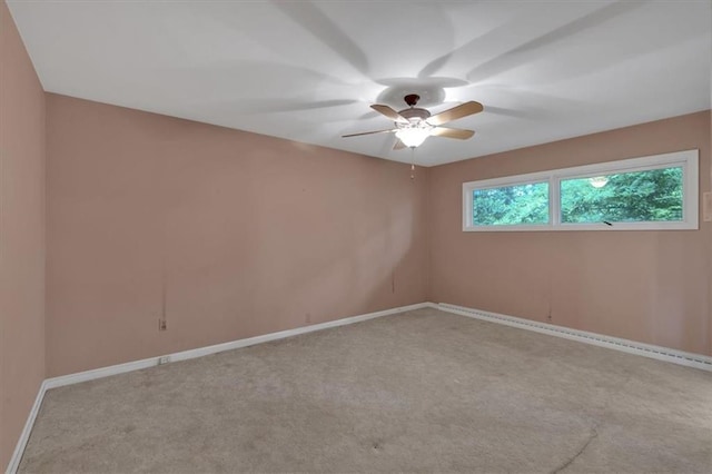 spare room featuring a ceiling fan, carpet, and baseboards