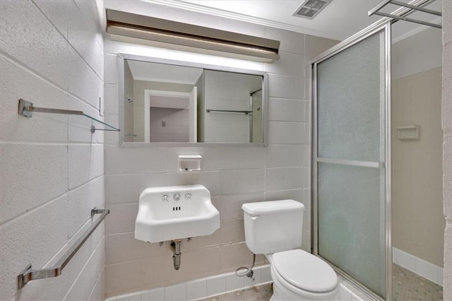 bathroom with a sink, toilet, and a stall shower