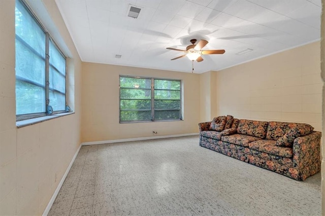 living area featuring a ceiling fan, baseboards, and tile patterned floors