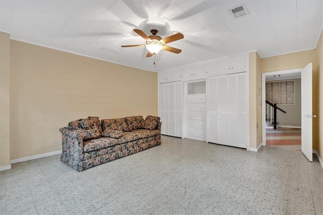 living area with ceiling fan, an upstairs landing, and baseboards