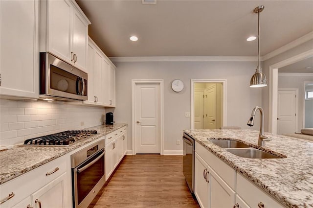 4335 Bellview Ln, Duluth, GA 30097 - kitchen featuring stainless steel appliances, crown molding, white cabinetry, decorative backsplash, and light wood finished floors