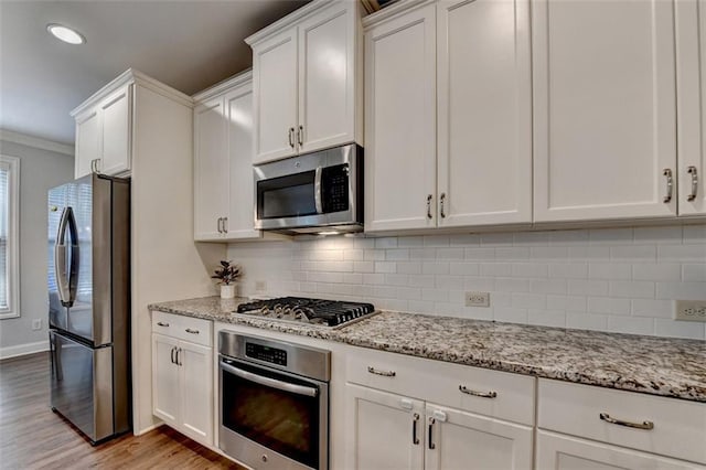 4335 Bellview Ln, Duluth, GA 30097 - kitchen with appliances with stainless steel finishes, light wood-style floors, white cabinets, crown molding, and decorative backsplash