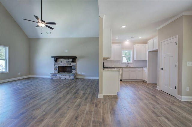 311 Arbor Cir, Rockmart, GA 30153 - unfurnished living room with a ceiling fan, wood finished floors, a stone fireplace, vaulted ceiling, and recessed lighting