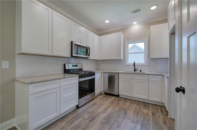 311 Arbor Cir, Rockmart, GA 30153 - kitchen featuring stainless steel appliances, light wood finished floors, white cabinetry, backsplash, and crown molding