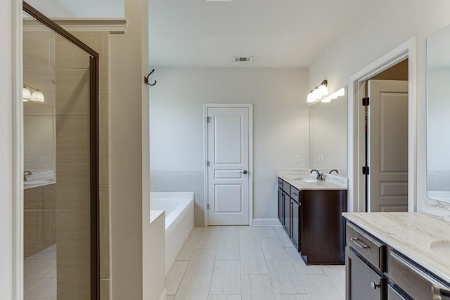 6206 Little Cove Dr, Flowery Branch, GA 30542 - bathroom featuring two vanities, a garden tub, a stall shower, and tile patterned floors