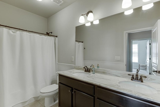 6206 Little Cove Dr, Flowery Branch, GA 30542 - full bathroom with wainscoting, double vanity, a shower with curtain, and tile patterned floors