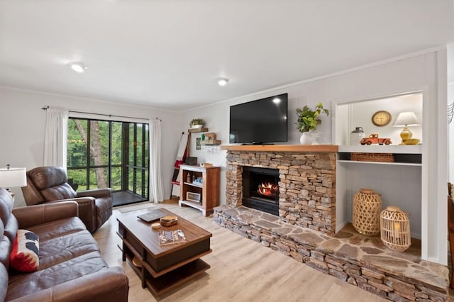 living area with a fireplace, crown molding, and wood finished floors