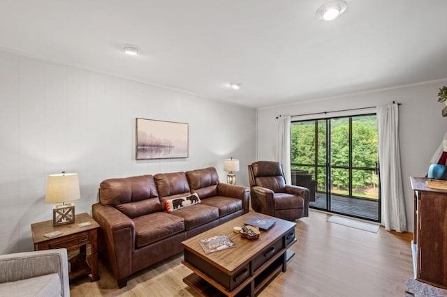 living area with ornamental molding and light wood-style flooring