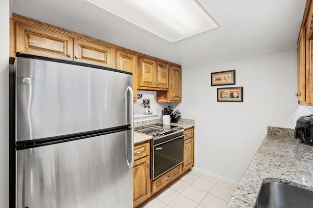 kitchen with light tile patterned floors, visible vents, brown cabinetry, appliances with stainless steel finishes, and a sink