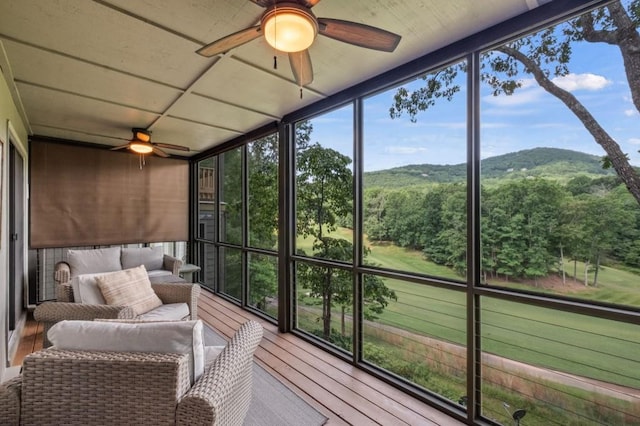 sunroom / solarium featuring a mountain view and a ceiling fan