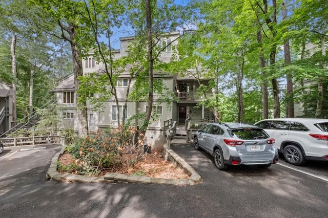 view of property with uncovered parking and stucco siding