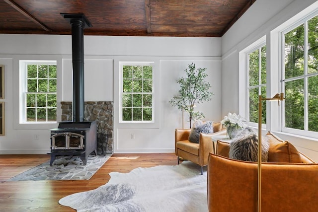 sunroom featuring a wood stove, healthy amount of natural light, and french doors