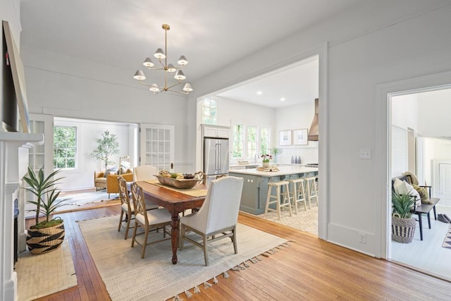 dining area featuring light wood-type flooring, a chandelier, and recessed lighting