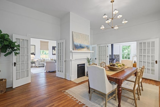 dining area with french doors, plenty of natural light, and a towering ceiling