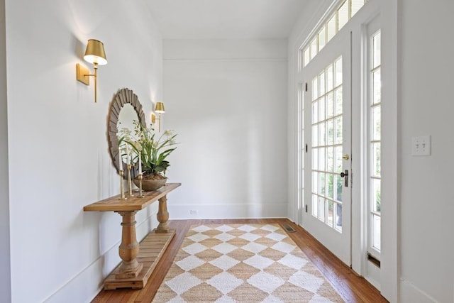 doorway featuring wood finished floors and baseboards