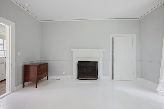 unfurnished living room with washer / dryer, a fireplace, and ornamental molding