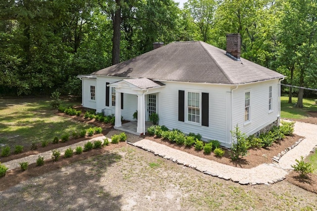 view of front of property with a chimney and roof with shingles