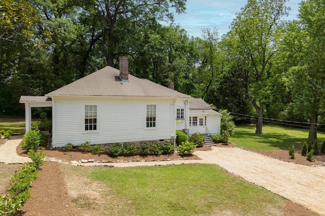 back of house featuring a chimney, driveway, a shingled roof, and crawl space