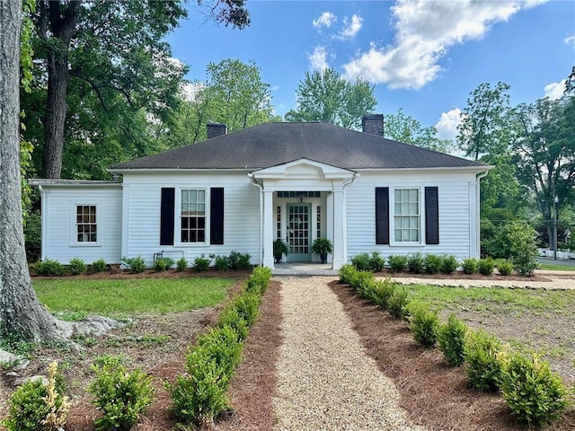 single story home featuring a chimney and a front yard