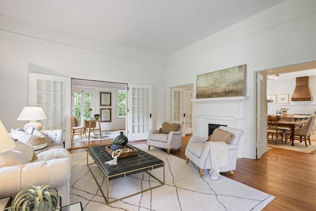 living room with wood finished floors, a fireplace, and french doors