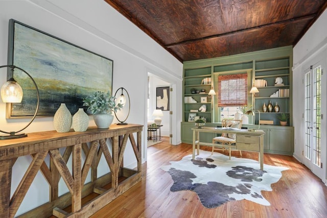 office space with built in features, light wood-type flooring, and wooden ceiling
