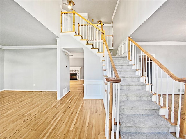 stairs featuring ornamental molding and wood-type flooring