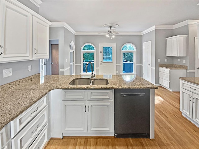 kitchen with white cabinets, light wood-type flooring, crown molding, and sink