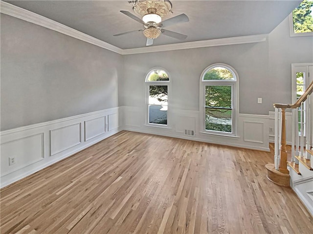 unfurnished room with ornamental molding, light wood-type flooring, and ceiling fan