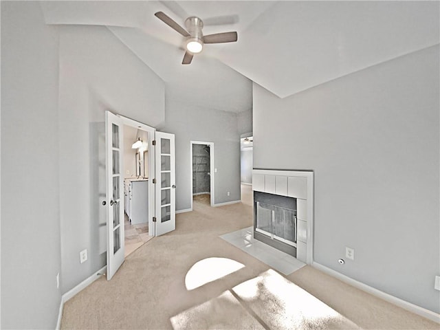 unfurnished living room with ceiling fan, french doors, and light carpet