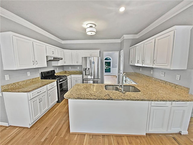 kitchen with stainless steel fridge, black gas stove, sink, kitchen peninsula, and white cabinetry