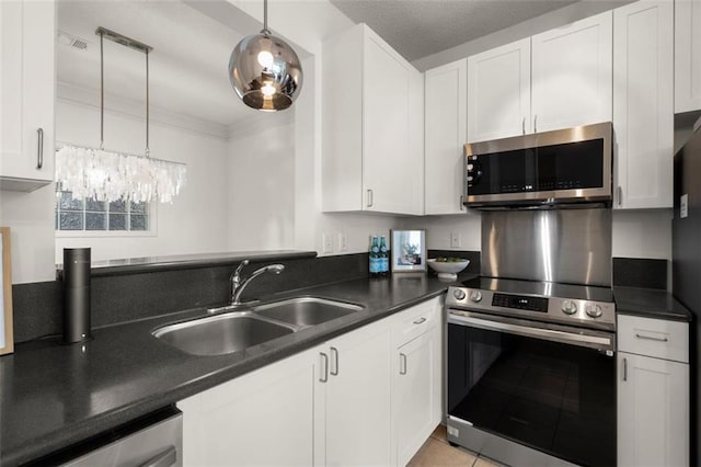 kitchen featuring appliances with stainless steel finishes, dark countertops, white cabinetry, and a sink