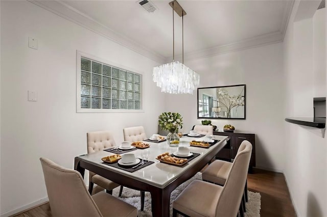 dining space with a healthy amount of sunlight, visible vents, crown molding, and wood finished floors