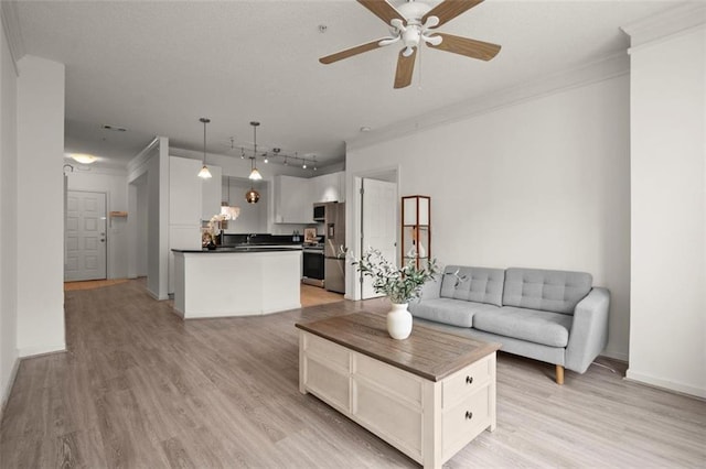 unfurnished living room featuring crown molding, a ceiling fan, and light wood-style floors