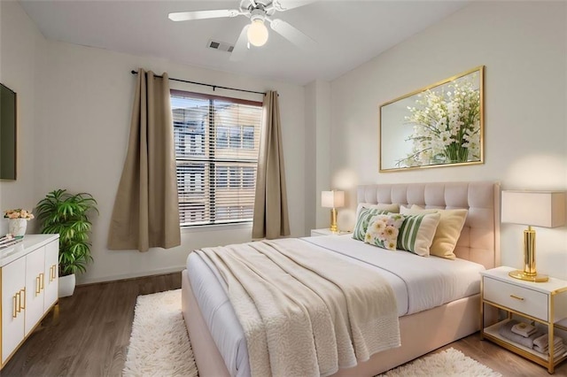 bedroom featuring ceiling fan, wood finished floors, visible vents, and baseboards